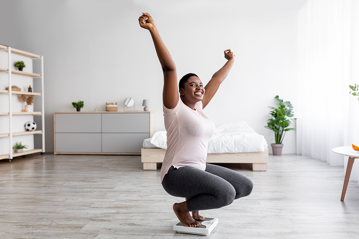 woman reaching arms up in air celebrating reaching health goals